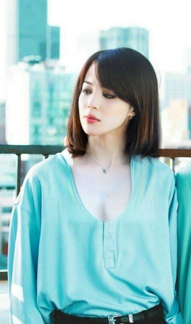 身穿藍色襯衫的女性在城市陽台上若有所思