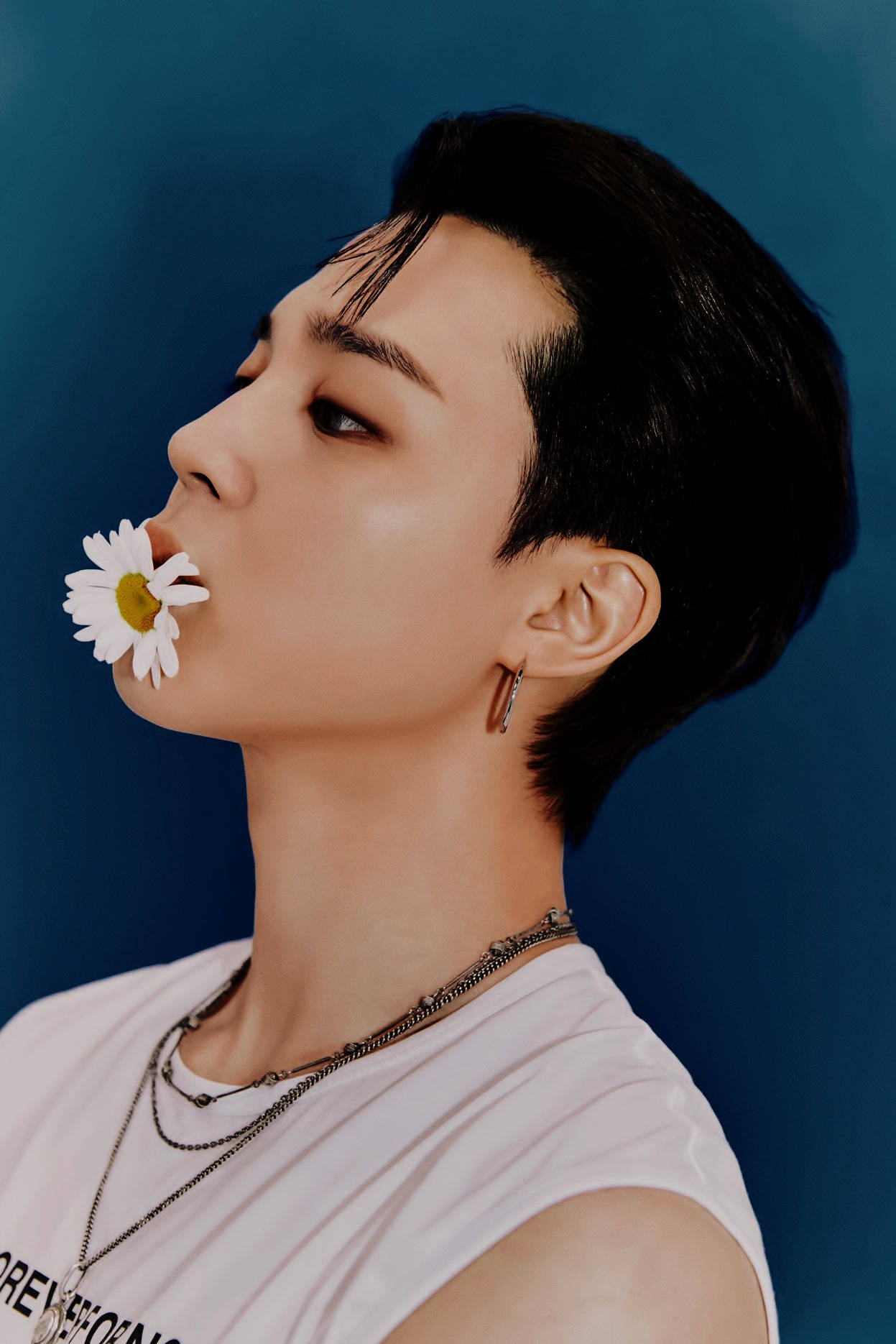 BTS 崔然竣 Weverse 雜誌專訪 壁紙 — 一位短黑髮的年輕男子嘴裡叼著一朵雛菊，背景為純藍色。