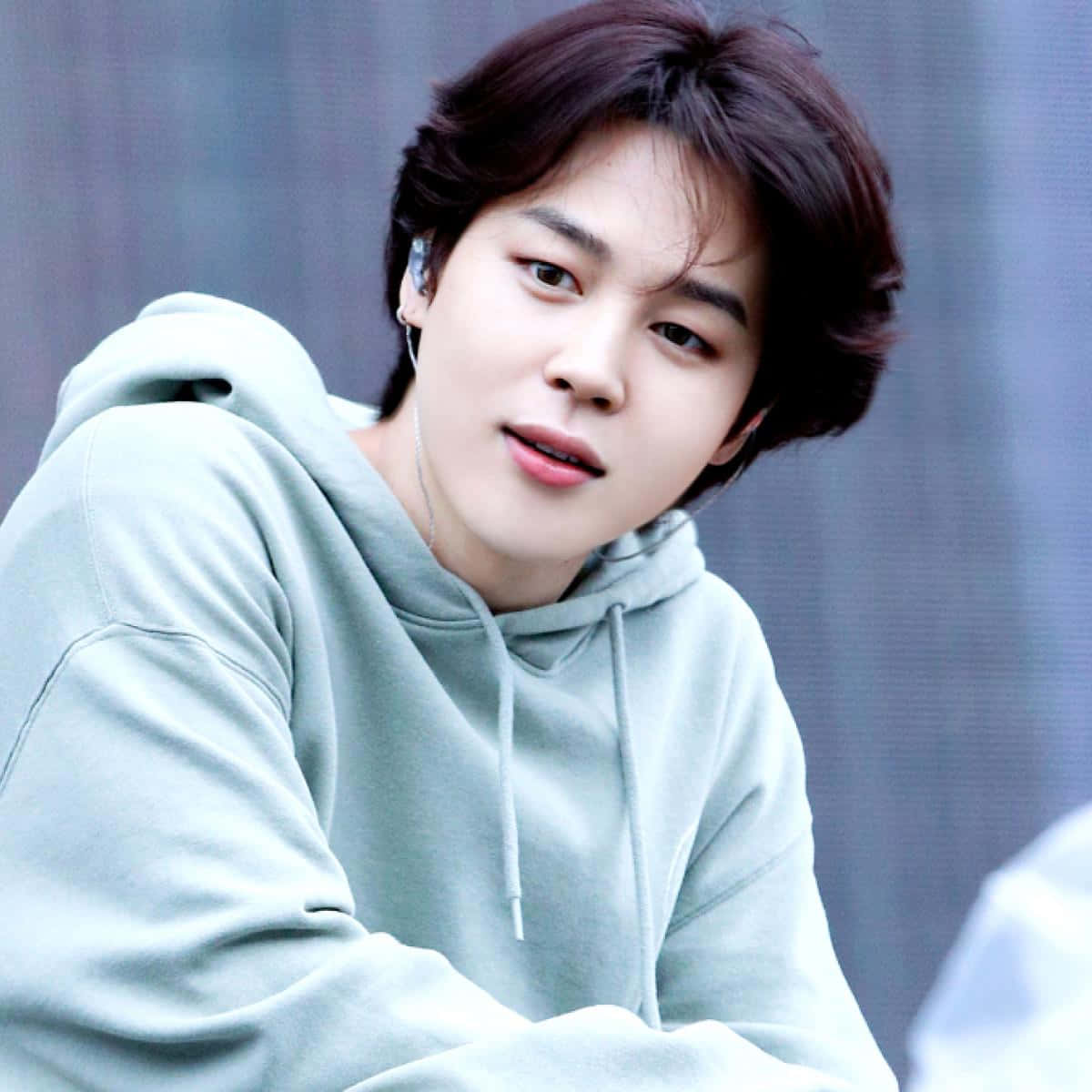 BTS 成員 Jimin，Billboard 音樂獎得主 壁紙 — 一位深色頭髮的年輕男子穿著淺綠色連帽衫，直視鏡頭，表情柔和。