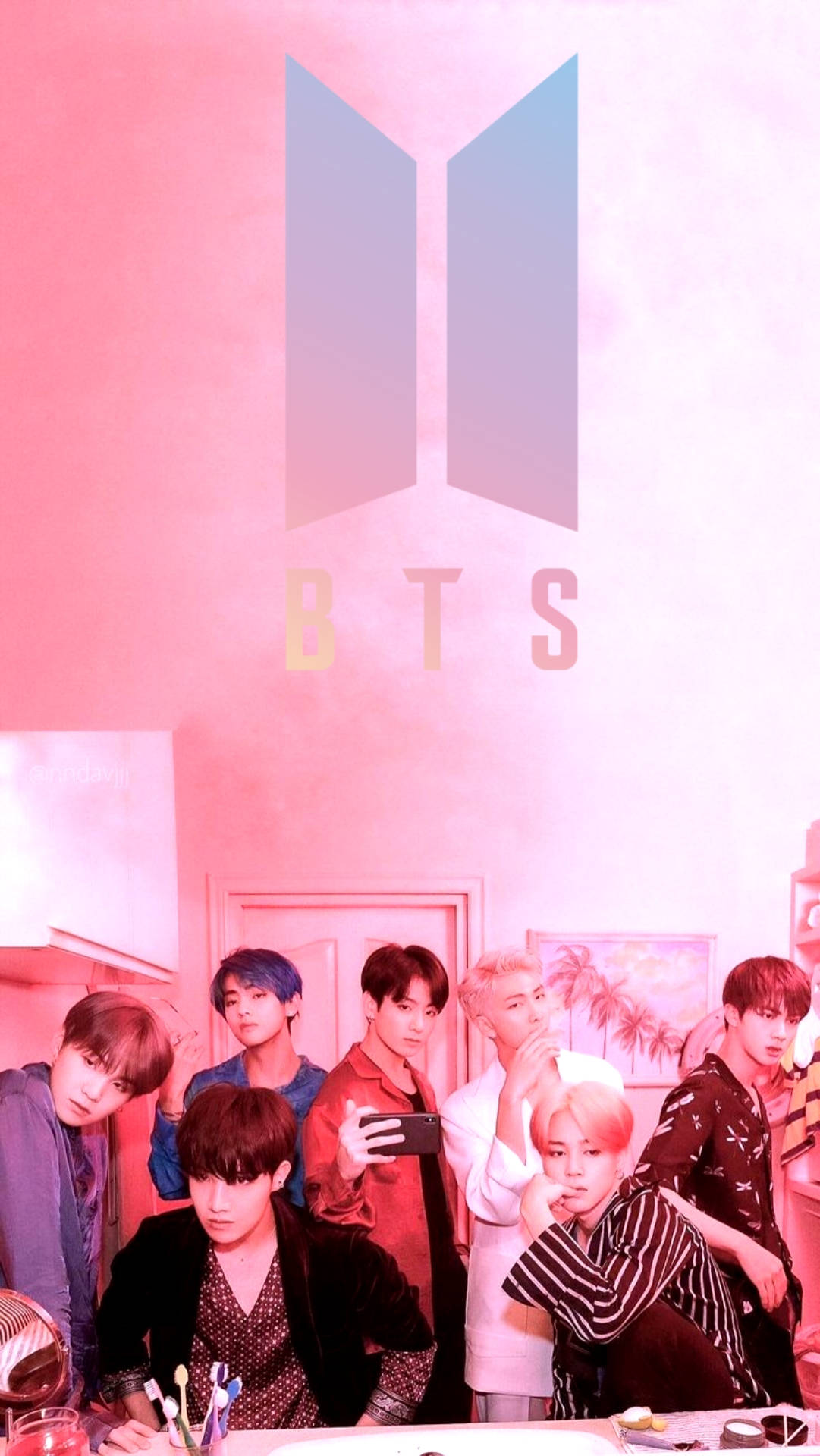 七位K-pop偶像在粉紅色燈光的工作室中，與BTS標誌和熱帶裝飾一起擺姿勢。
