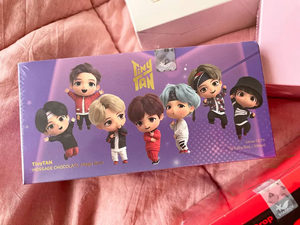 粉紅色布料上的TinyTAN BTS chibi朱古力棒。