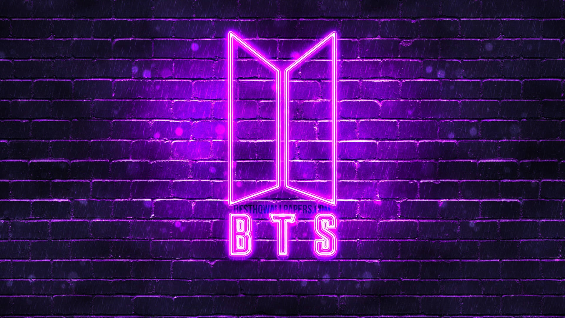 夜間濕磚牆上的紫色霓虹燈BTS標誌。