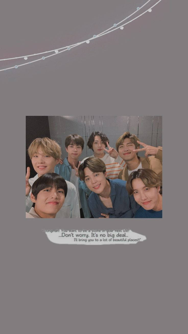 BTS 群體搞怪美學壁紙 壁紙 — 七位微笑的年輕男性在照片中一起擺姿勢，上方有燈串和引文疊加。