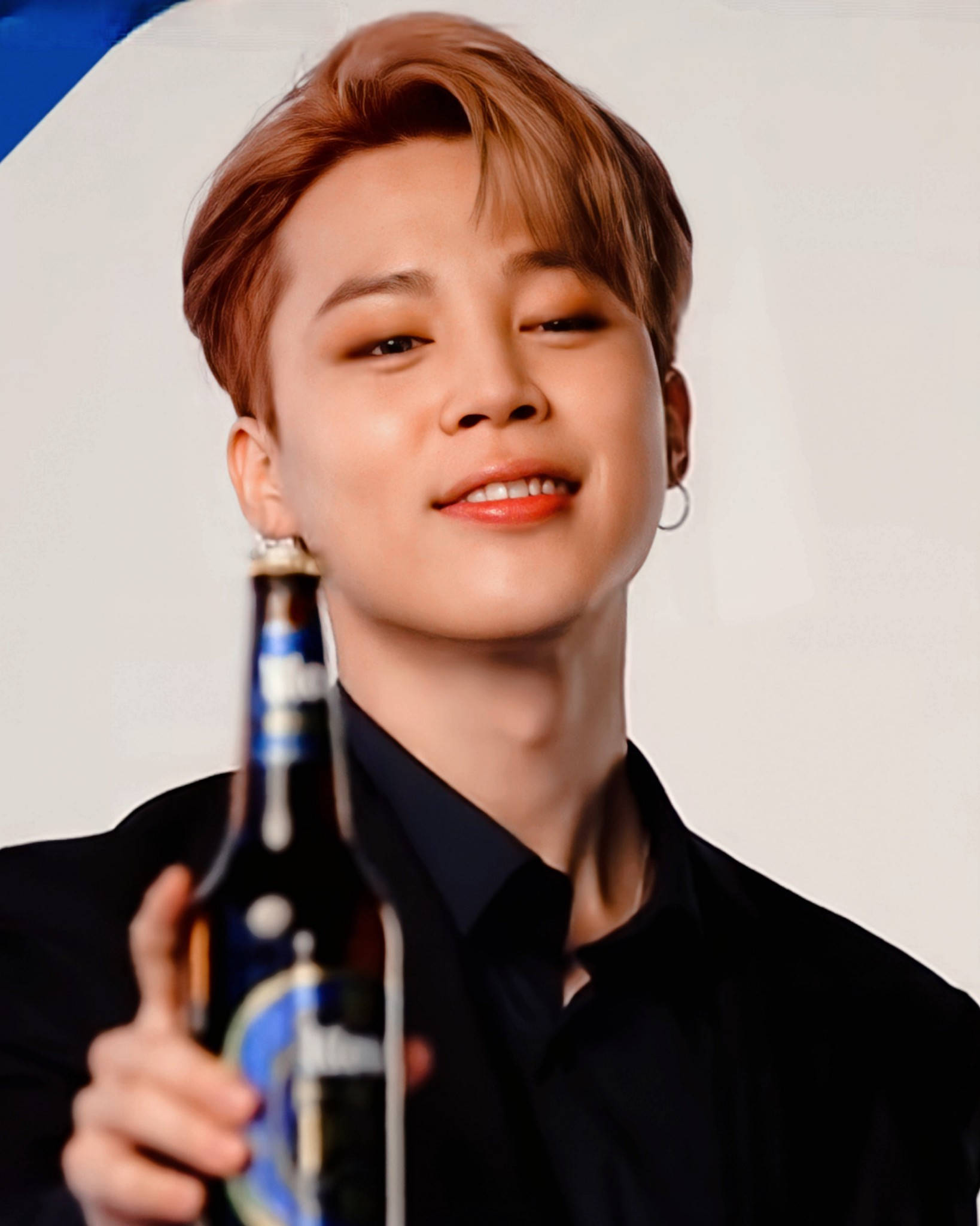 BTS 金珍洙為Kloud Beer代言 壁紙 — 一位年輕男子，留著造型棕色頭髮，戴著耳環，微笑著手持啤酒瓶，背景為純白色。