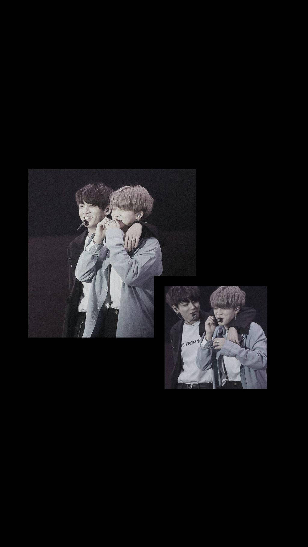 BTS黑色成員Jimin與Jungkook 壁紙 — 兩位年輕男子在昏暗燈光下、黑色背景的舞台上熱情擁抱。