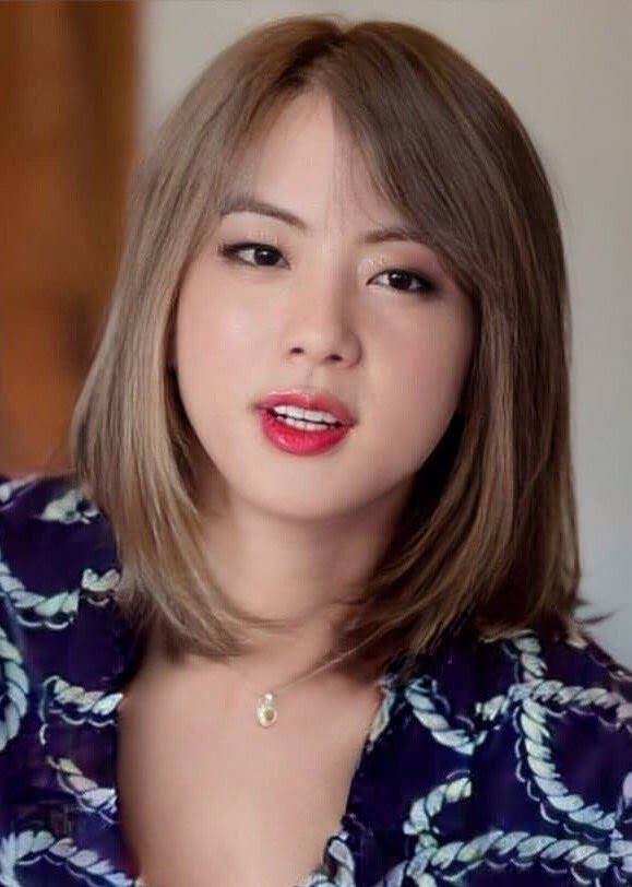 棕色頭髮和紅色唇膏的女性穿著紫色圖案上衣。