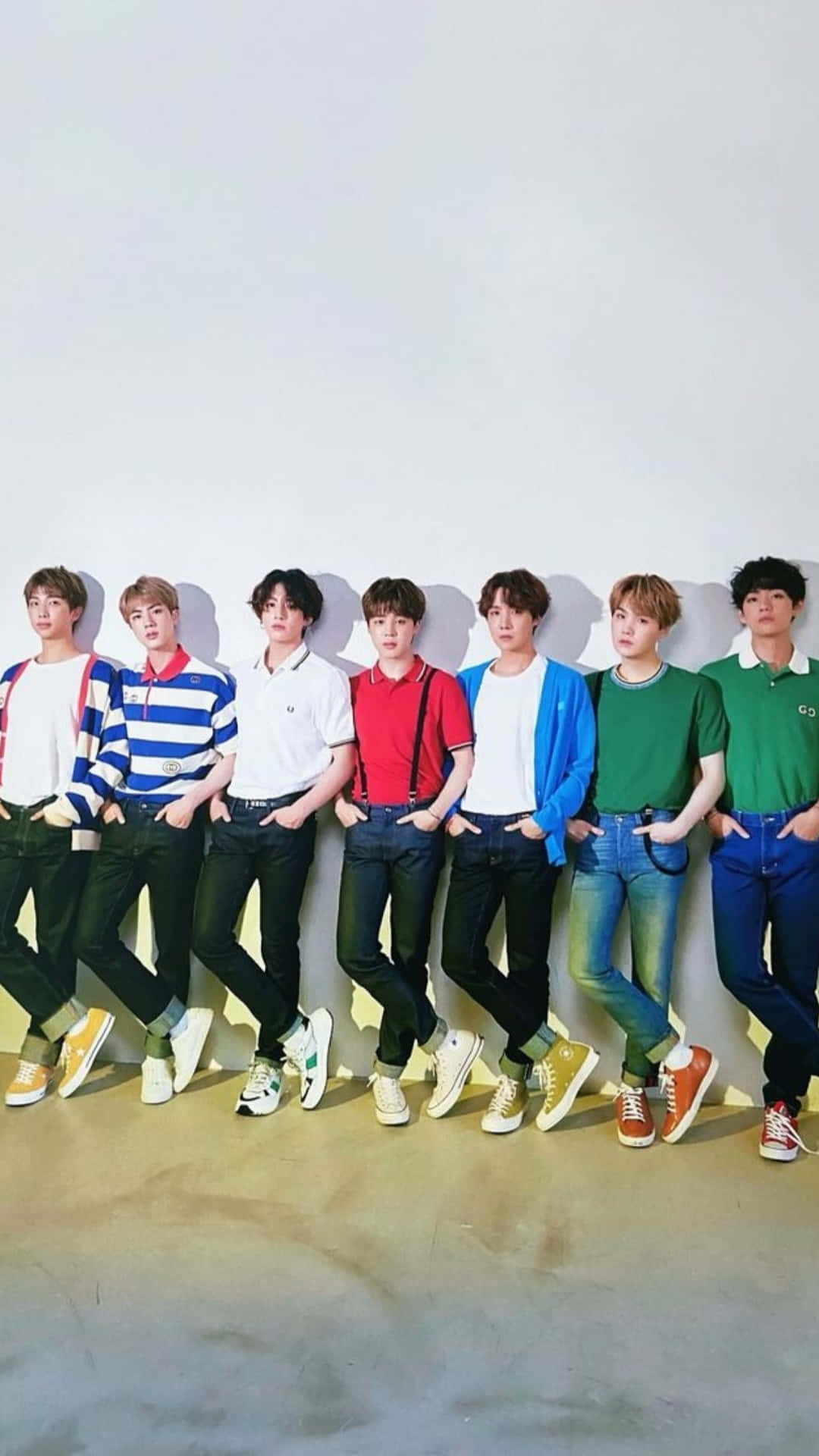 BTS彩色休閒服裝拍攝 壁紙 — 七位身穿色彩繽紛休閒服裝的年輕男性，以自信姿態靠在一面純白牆上。