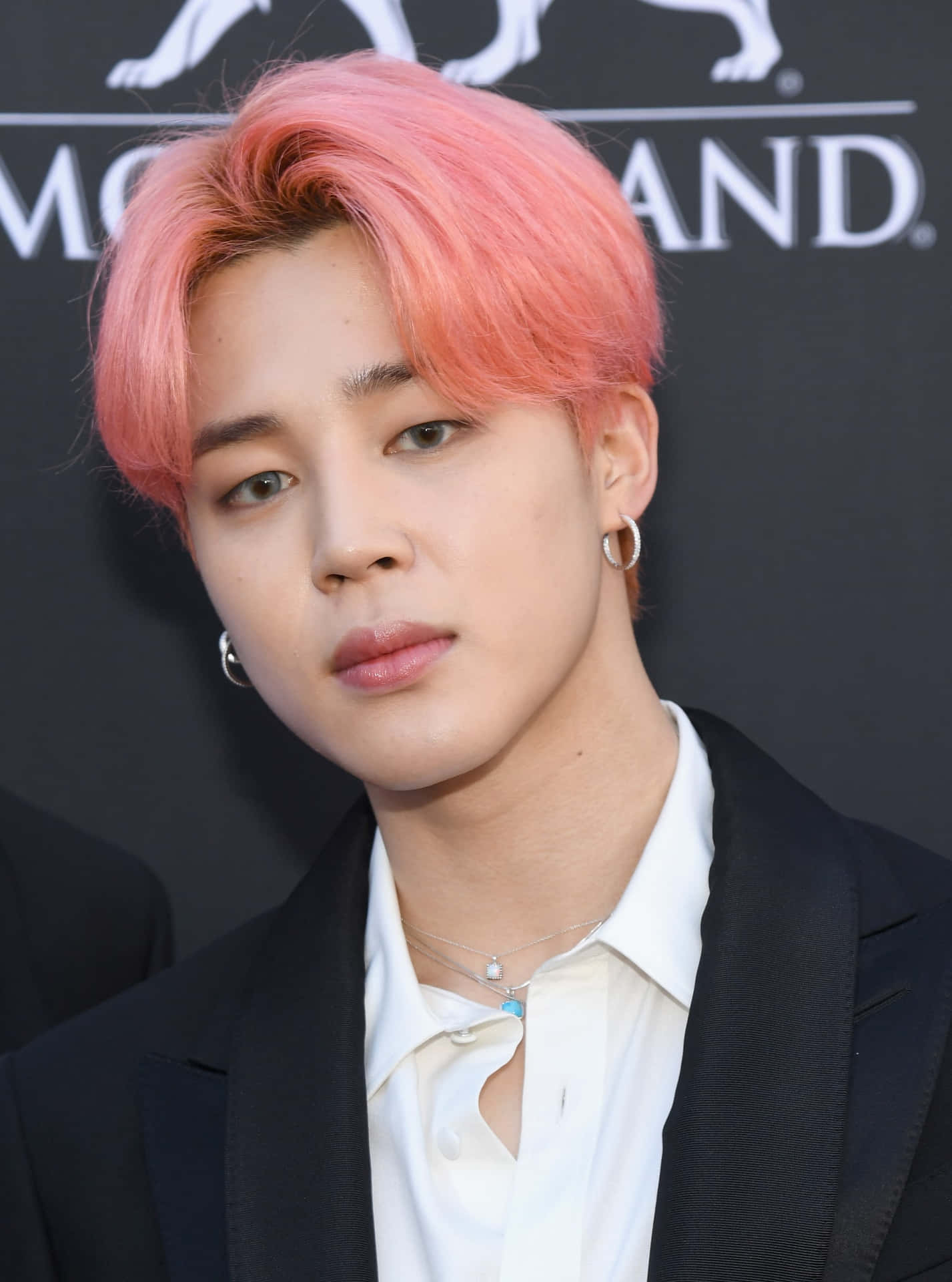 年輕男子，粉紅色頭髮和耳環，黑色西裝和白色襯衫。 — Jimin GIF 壁紙