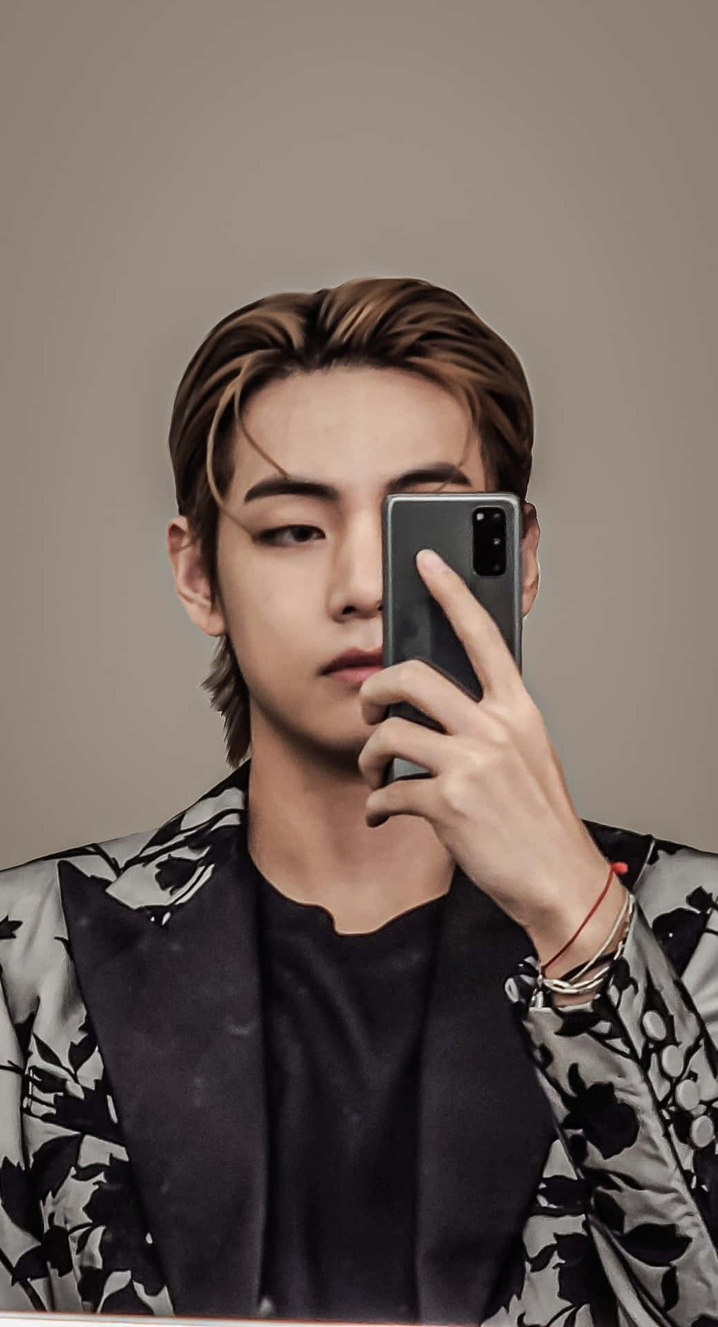 BTS成員鏡前自拍 壁紙 — 一位年輕男子梳著時尚髮型，手持智能手機在純米色背景前對著鏡子自拍。