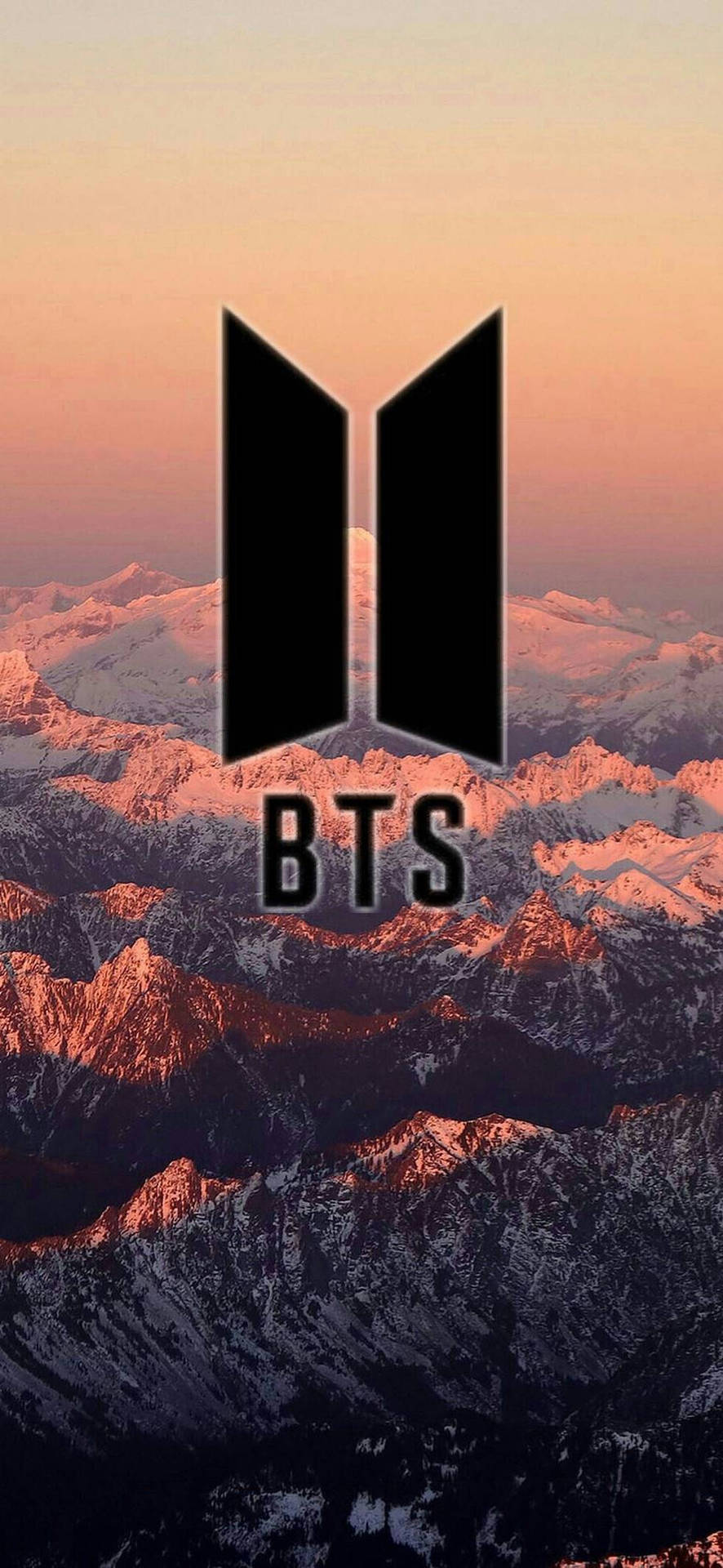 夕陽下雪山山脈上的 BTS 標誌