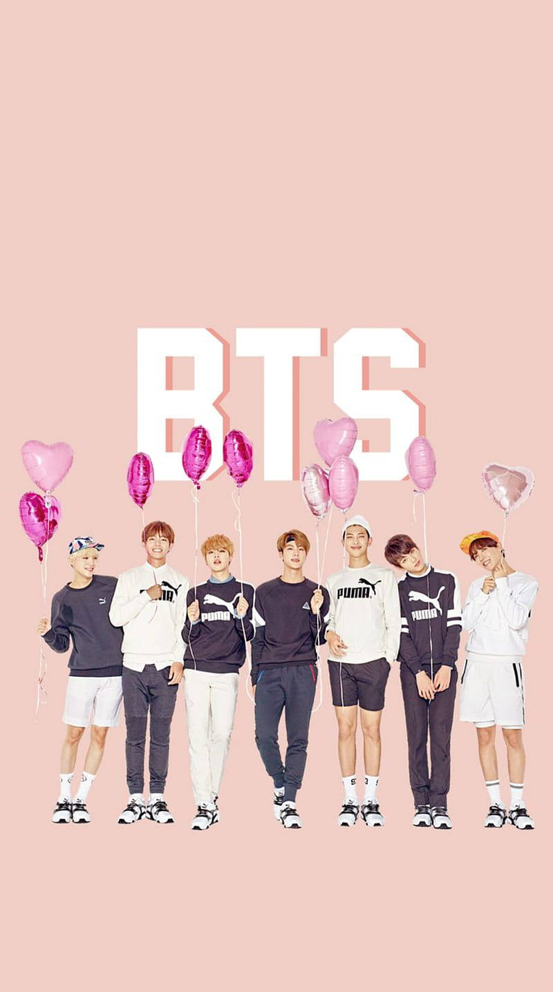 BTS粉紅氣球可愛風 壁紙 — BTS 七位成員站成一排，手持粉紅色心形氣球，背景是柔和的粉紅色，上方有大型白色 'BTS' 字母。