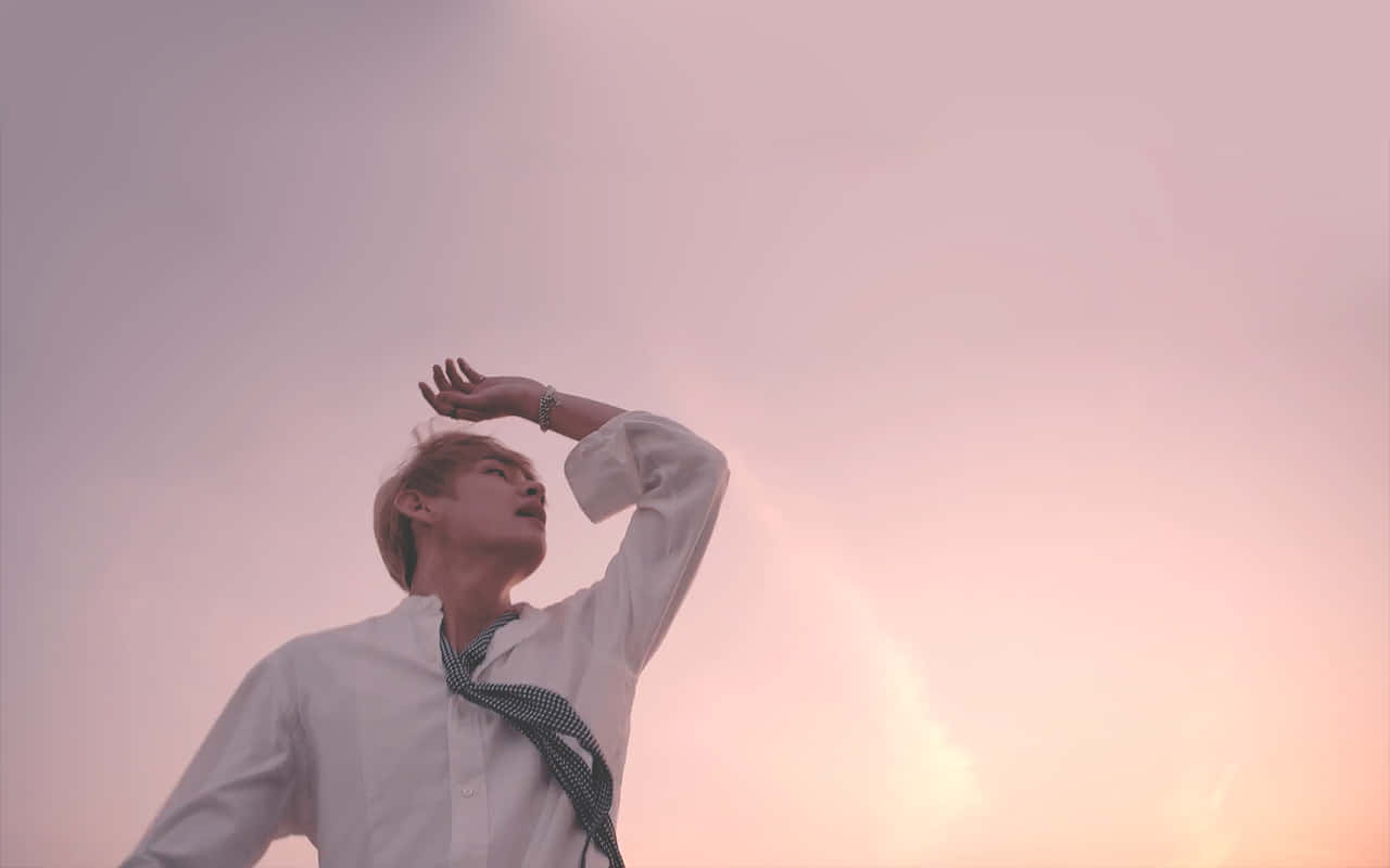身穿白襯衫和領帶的年輕男子遮擋夕陽餘暉。