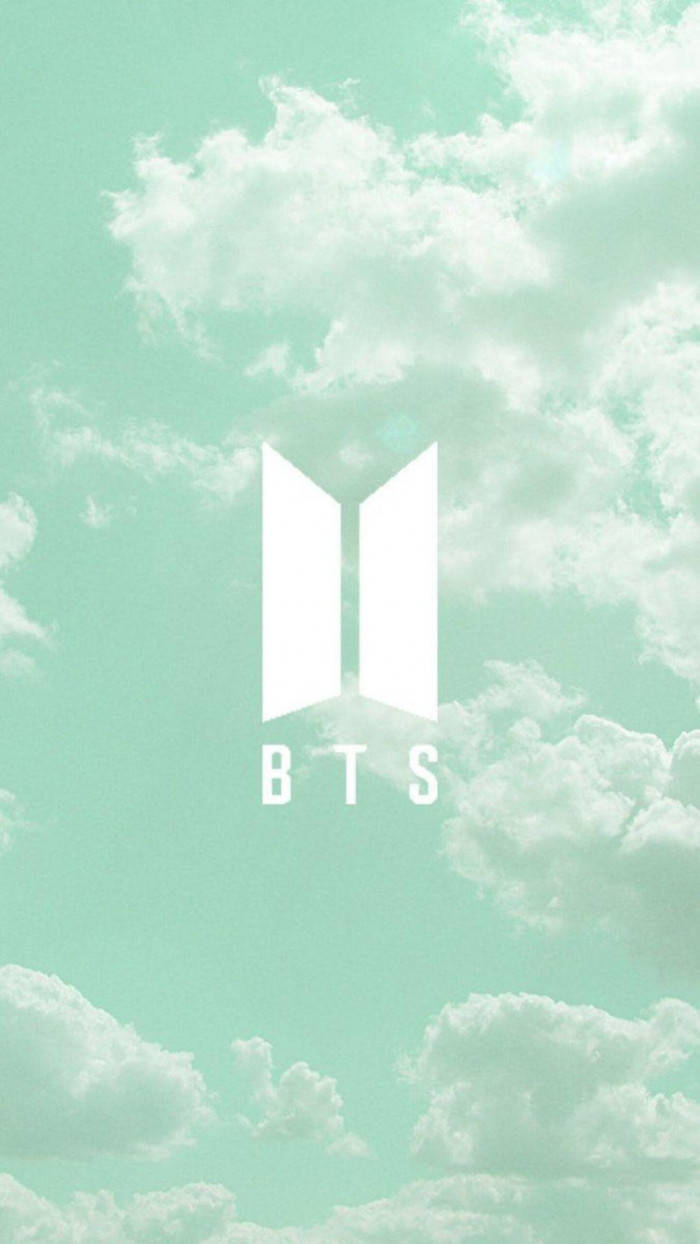 BTS薄荷綠美學 壁紙 — 白色BTS標誌漂浮在柔和的薄荷綠色天空上，天空充滿蓬鬆的白雲。