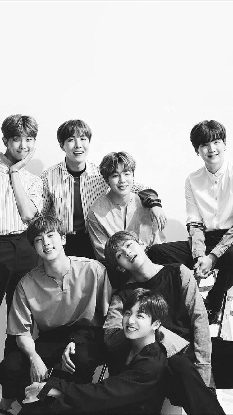 BTS黑白《Nonno》雜誌封面拍攝 壁紙 — 七位微笑的年輕男士穿著休閒襯衫，在純白色背景前一起擺姿勢，拍攝黑白照片。