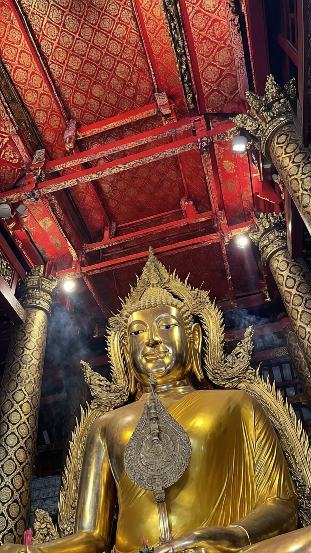 金色佛像在寺廟中，紅色天花板和飄散的香煙