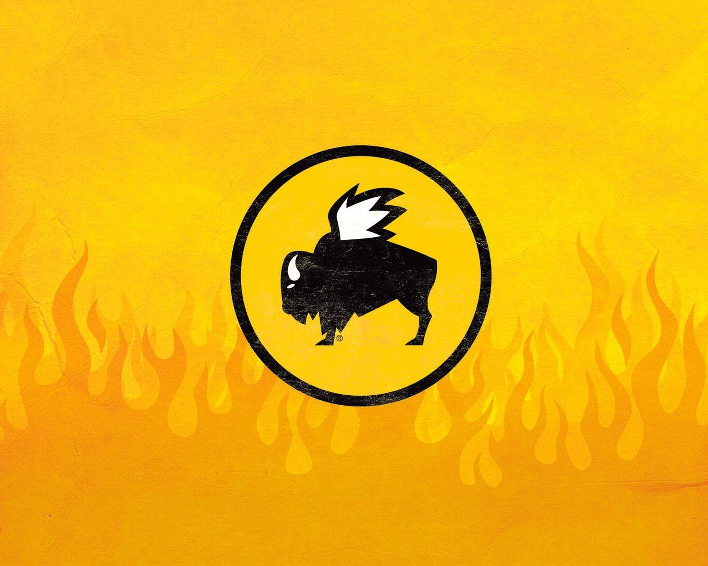 Buffalo Wild Wings 焰火設計 壁紙 — 一個大膽的黑色水牛標誌，帶翅膀，位於圓圈內，背景為火黃色，帶有火焰圖案。