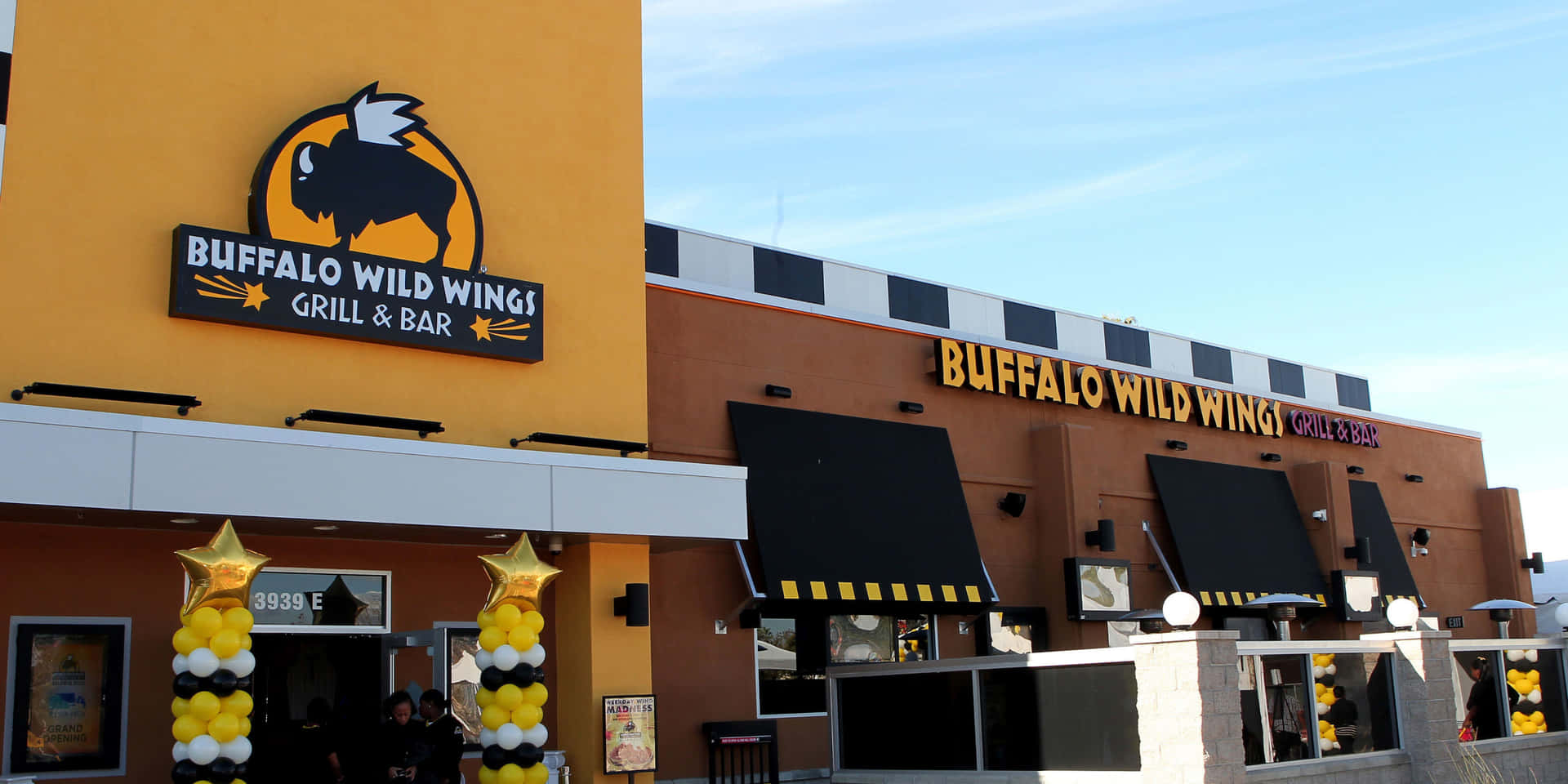 Buffalo Wild Wings 餐廳，外觀為橙色和黑色，並有黃色氣球。