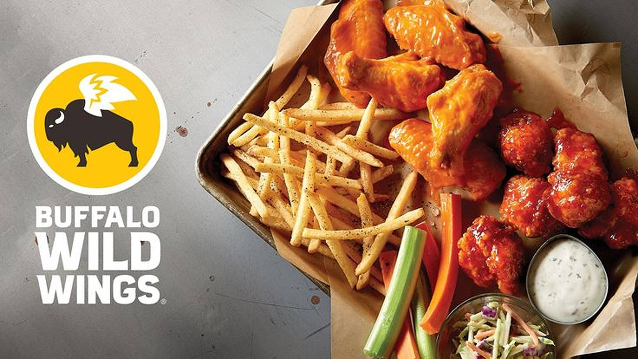 Buffalo Wild Wings 食物托盤 壁紙 — 一個金屬托盤上放著脆皮水牛雞翼、薯條、芹菜條和涼拌椰菜絲，旁邊有Buffalo Wild Wings標誌，置於灰色表面上。