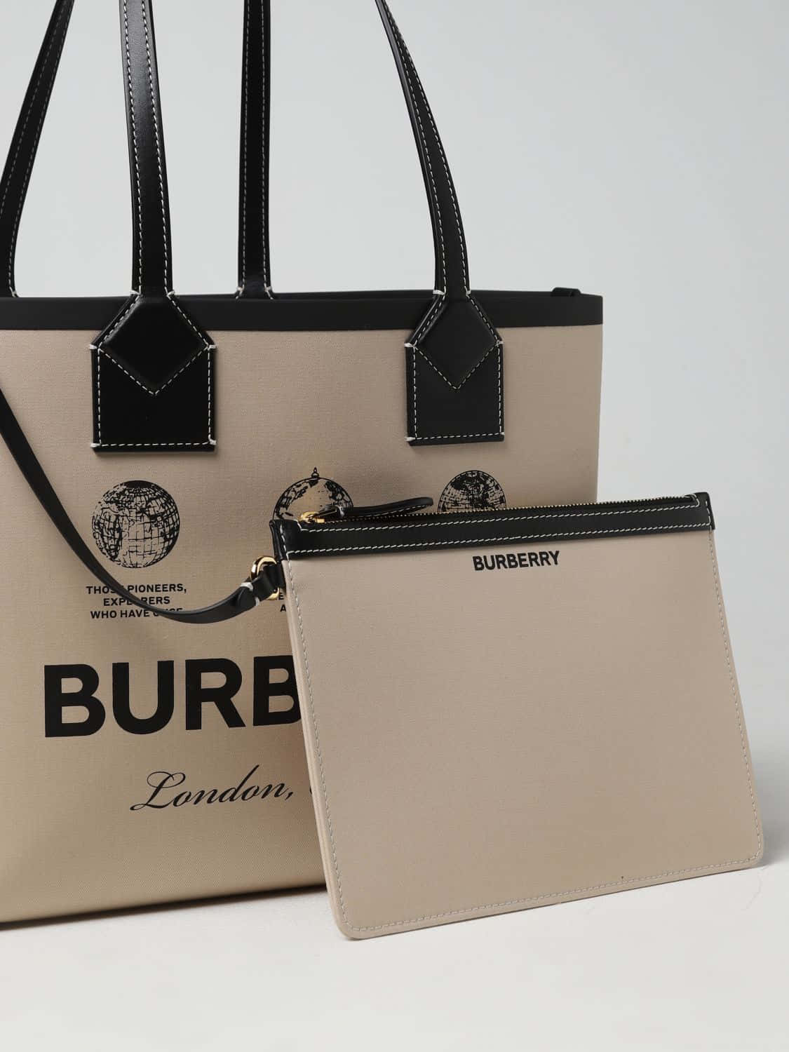 從倫敦到全球，慶祝 Burberry 壁紙 — 優雅的米色 Burberry 手提袋和收納袋，帶有黑色皮革飾邊和地球圖案，背景為純白色。