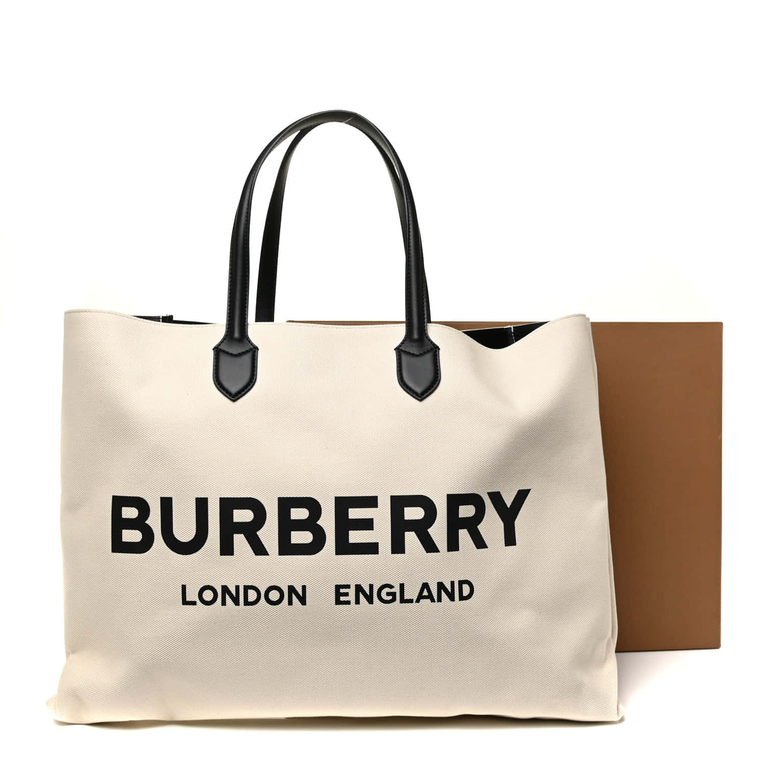 以 Burberry 奢華時尚定義您的風格 壁紙 — 一個米色Burberry手提袋，配有黑色手柄和醒目標誌，放在白色背景前的棕色盒子旁邊。