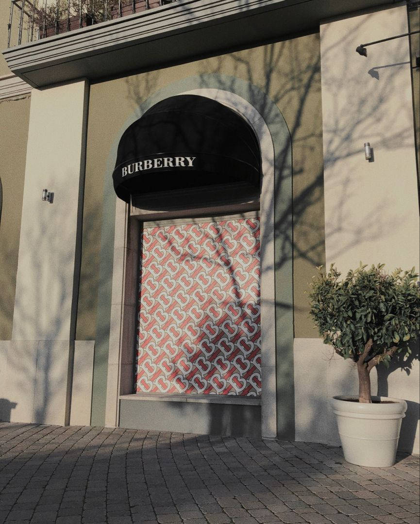 Burberry 店舖正面，圖案櫥窗及樹影投射在石鋪路面。