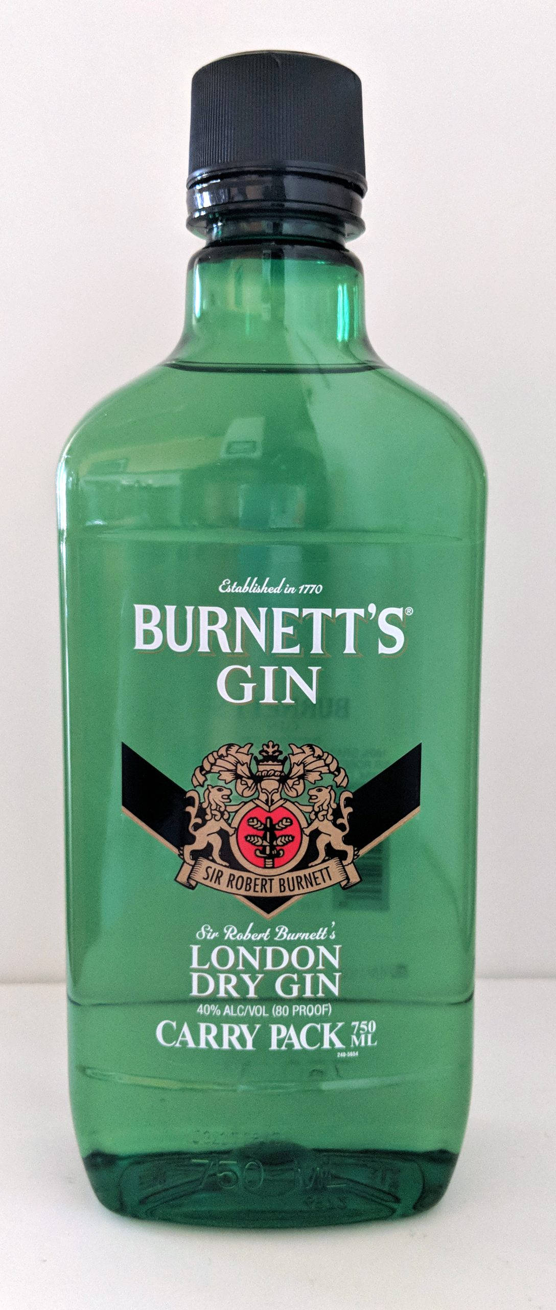 Burnett's金酒便攜包裝瓶 壁紙 — 一個帶有黑色蓋子和復古紋章標籤的Burnett's London Dry Gin綠色玻璃瓶，立在純白色背景前。