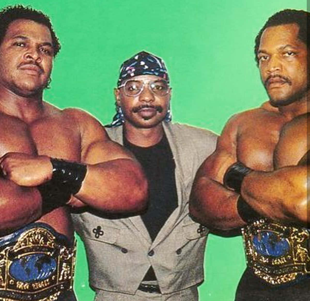 Butch Reed 與 Theodore Long 壁紙 — 三位肌肉發達的摔角手自信地擺姿勢，背景是明亮的綠色屏幕，腰間繫著冠軍腰帶。