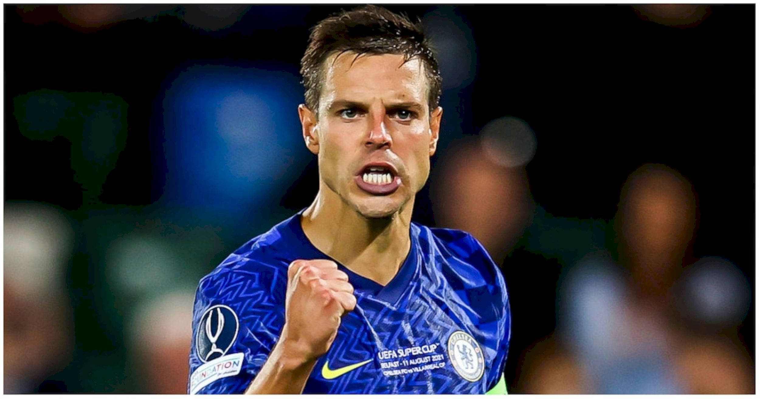César Azpilicueta 賽場握拳慶祝 壁紙 — 一名身穿藍色車路士球衣的足球運動員在球場燈光下緊握拳頭，神情專注。