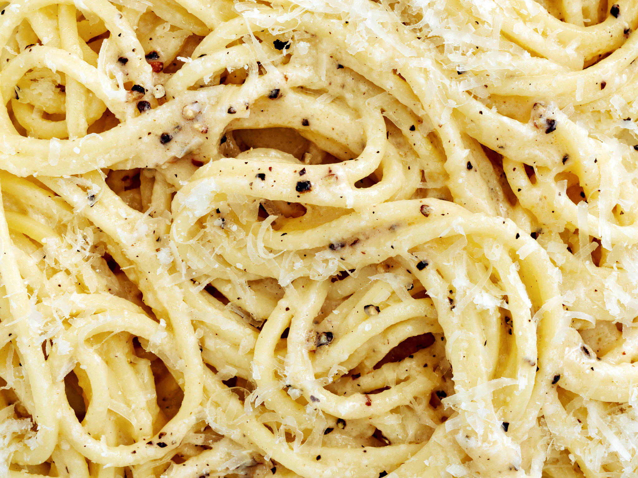 Cacio E Pepe 近照 壁紙 — 忌廉意粉近鏡，覆蓋著磨碎芝士和黑胡椒，可見意粉條和調味料。