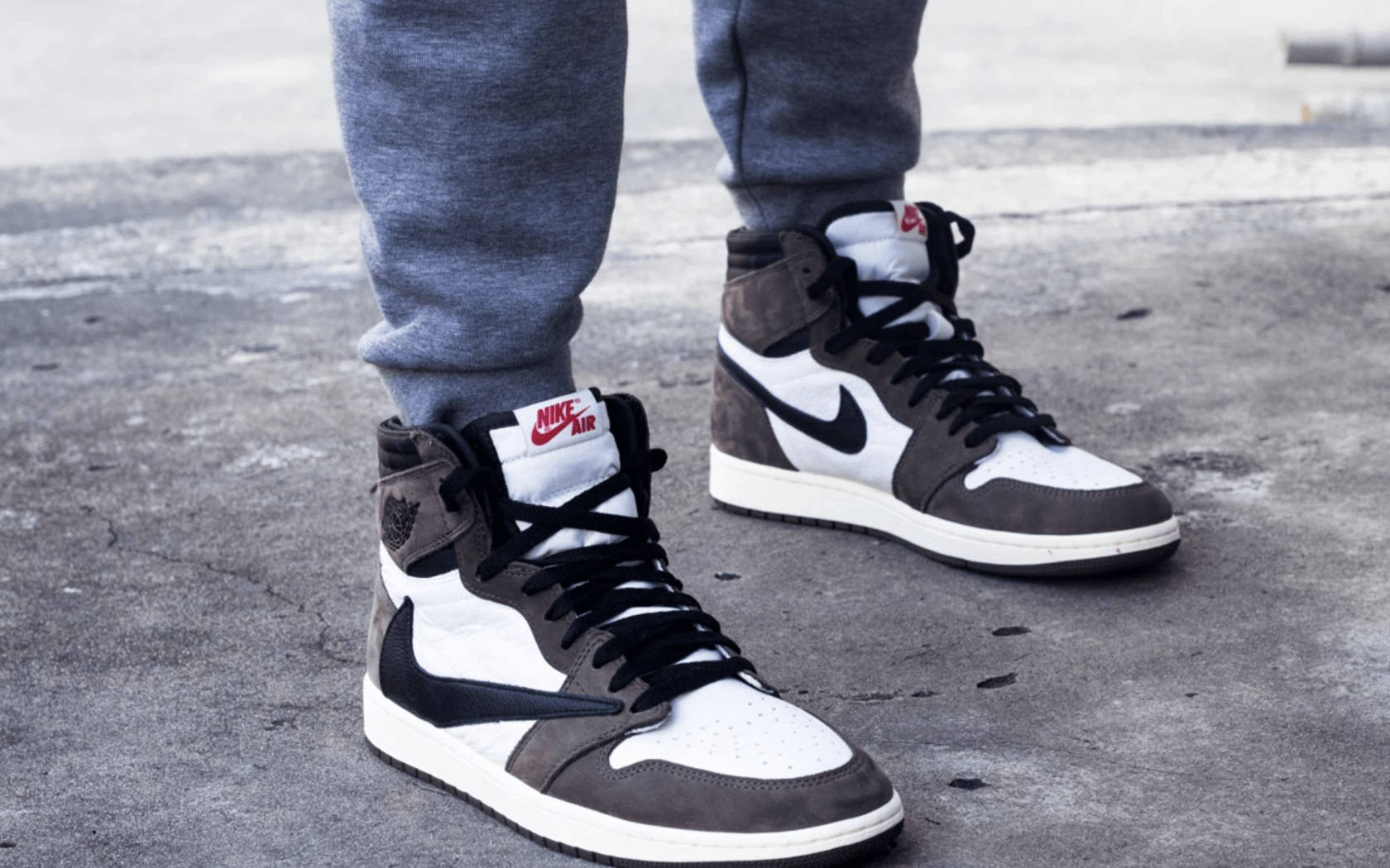 穿著灰色運動褲和黑白灰色Nike Air Jordan波鞋的人在路上。