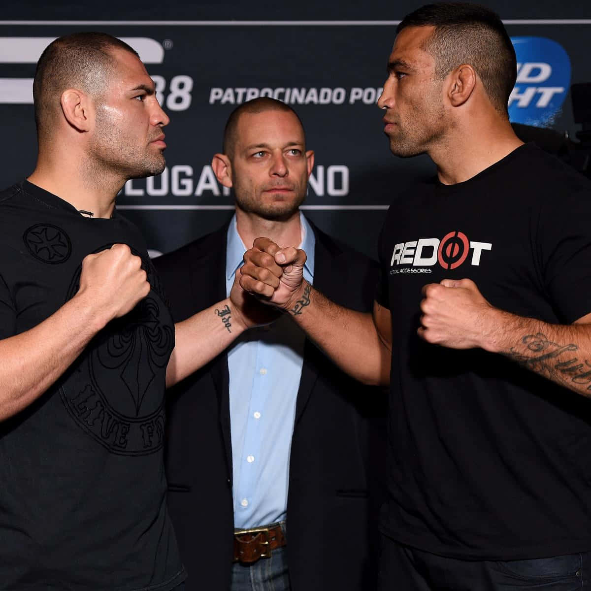 Cain Velasquez 與 Fabricio Werdum 對峙 壁紙 — 兩名拳手緊握拳頭對峙，裁判在緊張的賽前時刻握住他們的手。