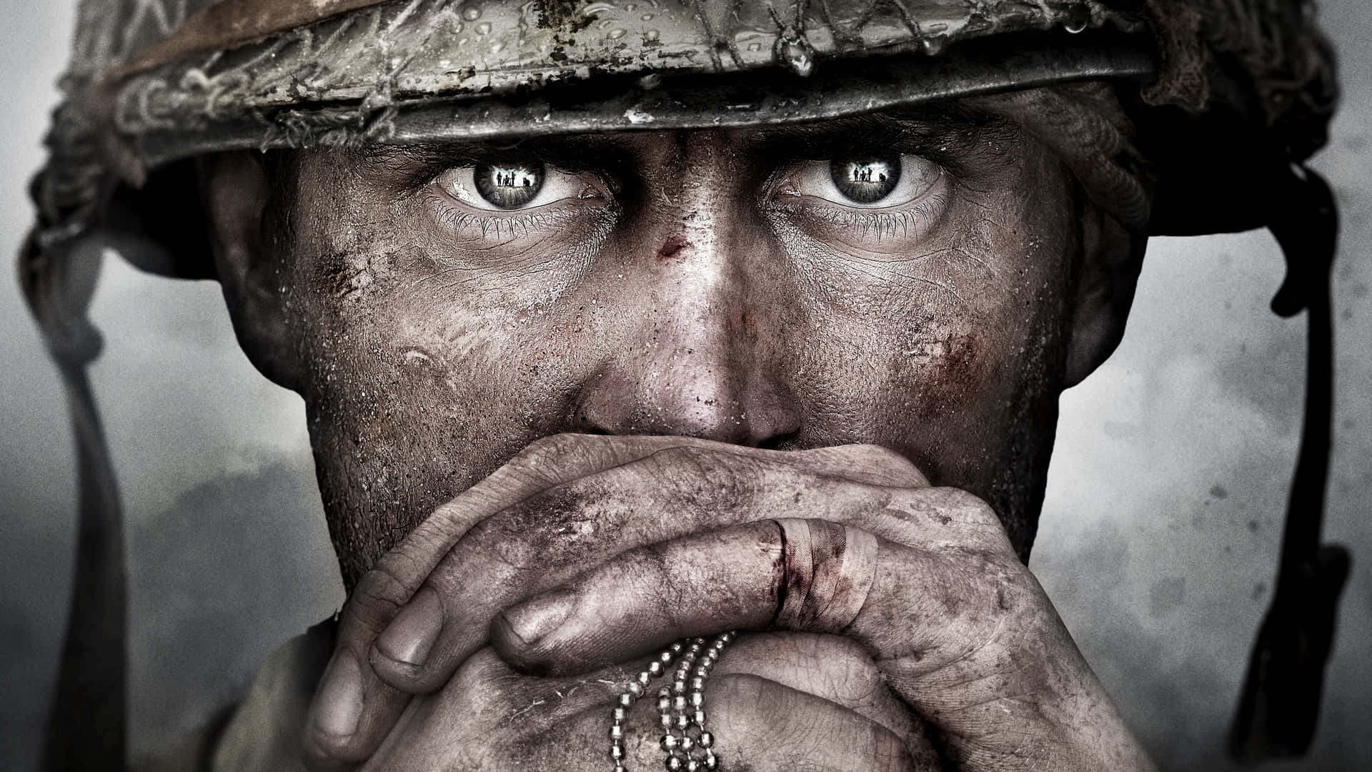 《Call of Duty》戰場瞬間 壁紙 — 一名在戰鬥中留下傷痕的士兵的近照，沾滿鮮血的雙手在泥濘的頭盔下掩蓋著嘴巴。