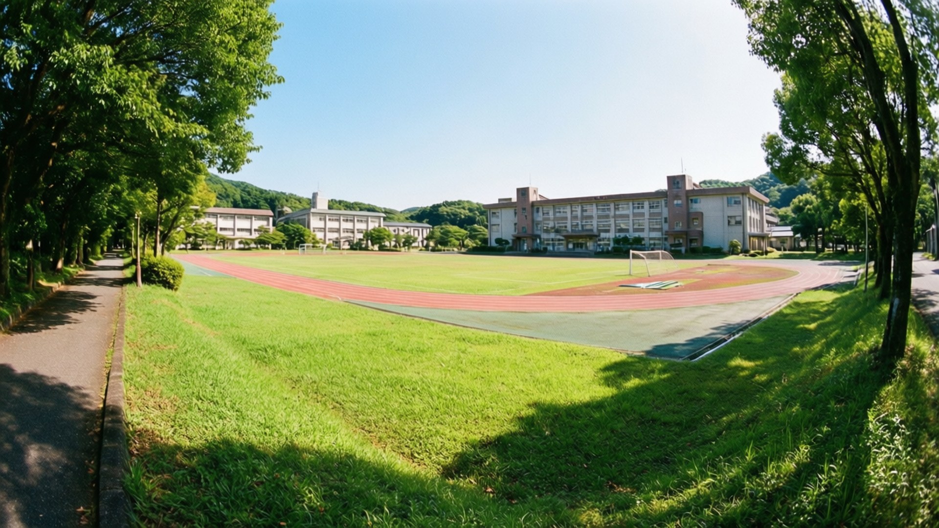 學校園區，在晴朗藍天下設有跑道和草地操場。
