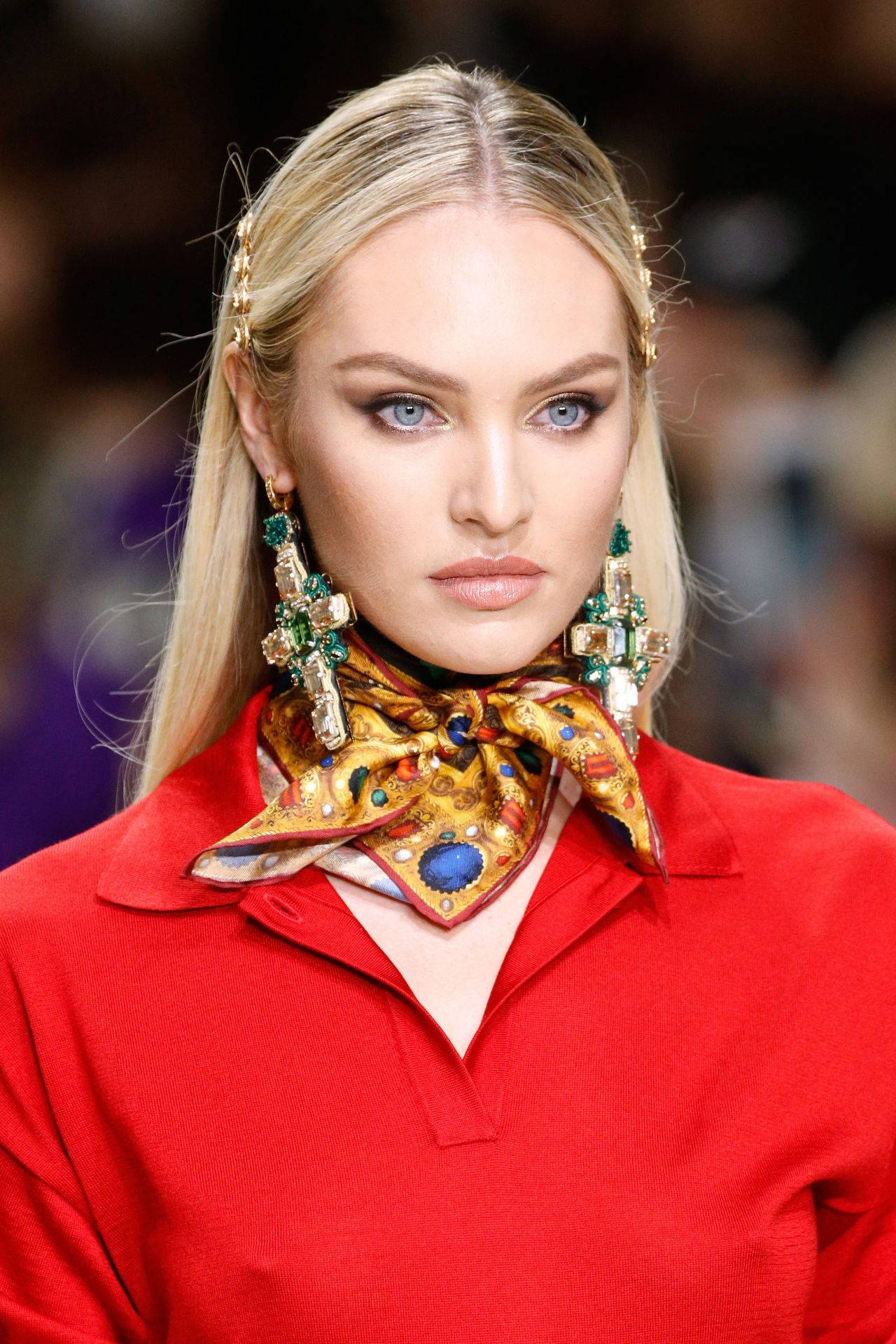Candice Swanepoel Versace 2018 跑道時裝 壁紙 — 一位金髮碧眼的模特兒穿著大膽的紅色上衣和華麗的珠寶耳環，在時裝天橋上行走。