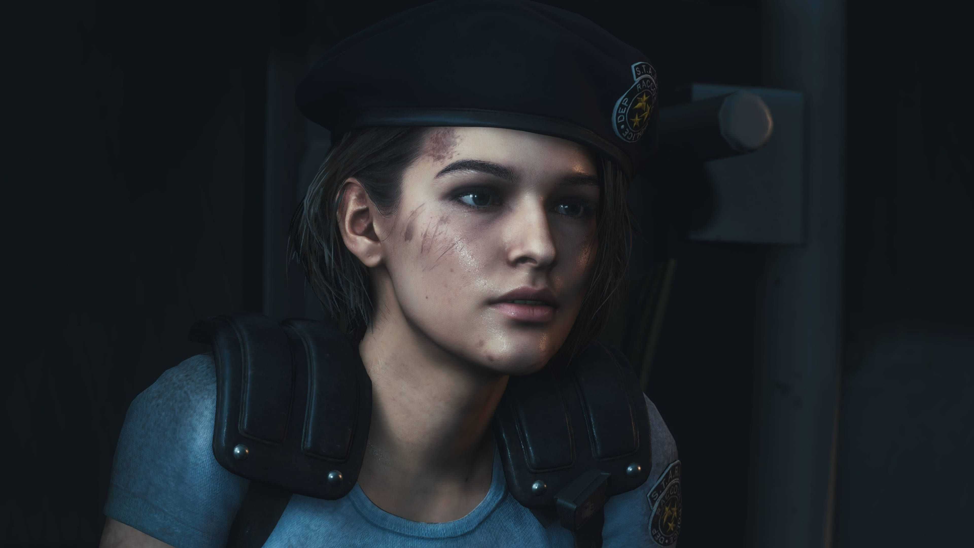 Capcom《生化危機》吉爾·瓦倫丁 壁紙 — 一位疲憊的女警，臉上帶有瘀傷，身穿戰術裝備，在光線昏暗的走廊中專注地凝視。