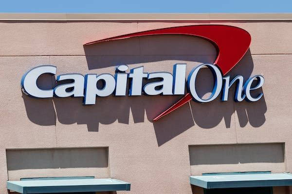 米色建築物上的 Capital One 銀行標誌，帶有紅色弧線和白色字母。