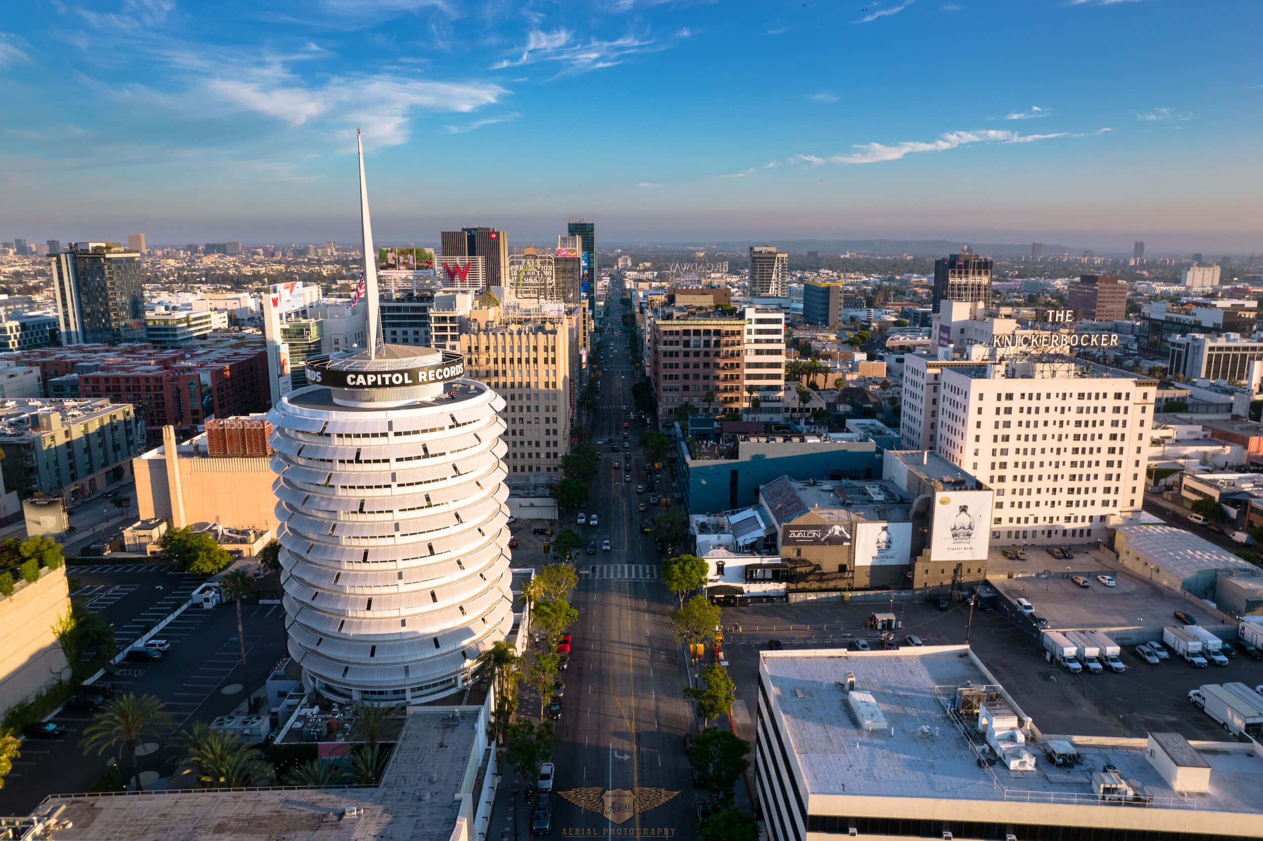 Capitol Records大樓的美麗景觀 壁紙 — 洛杉磯標誌性 Capitol Records 大樓的鳥瞰圖，陽光普照的街道和城市天際線在藍天下展現。