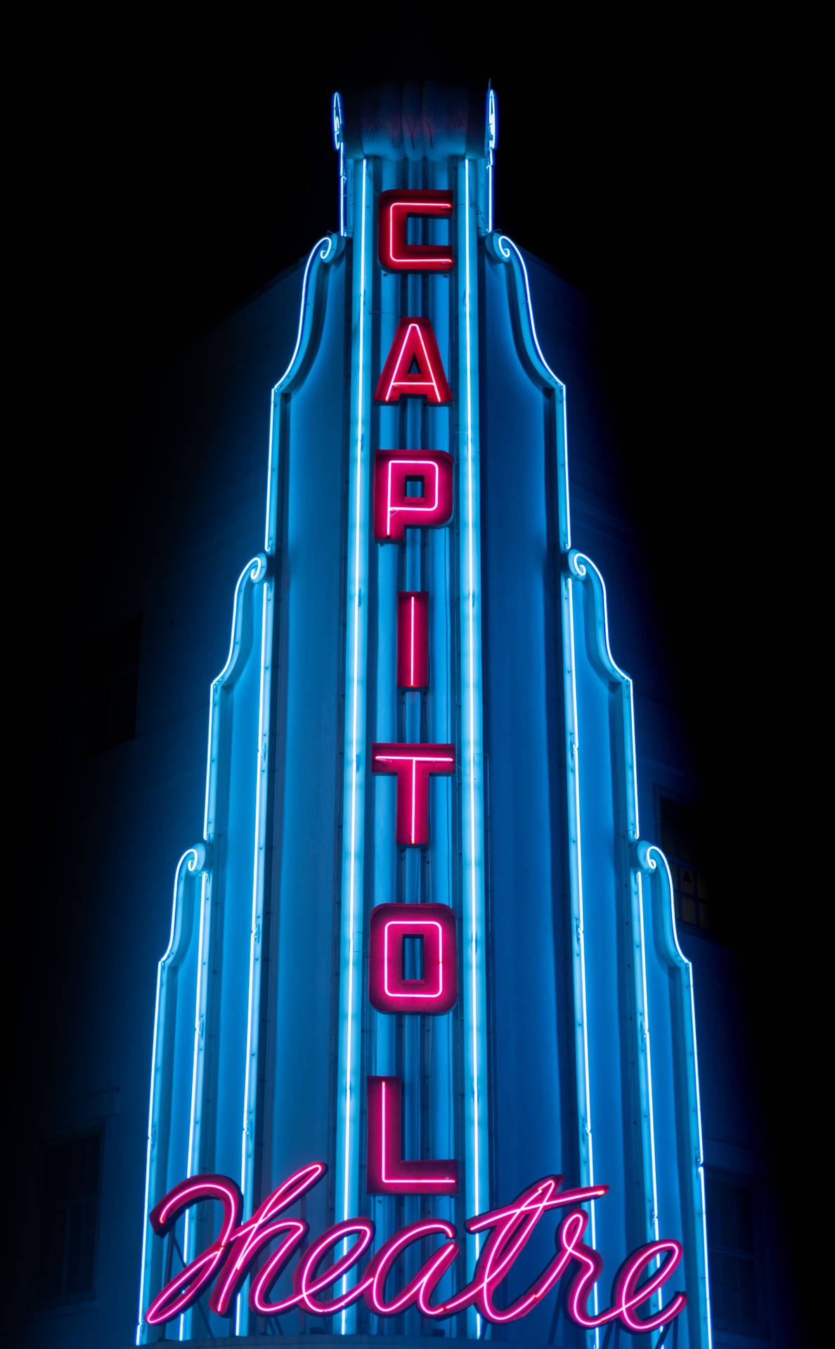 Capitol Theatre 的霓虹招牌在夜晚以藍色和粉紅色燈光閃耀。