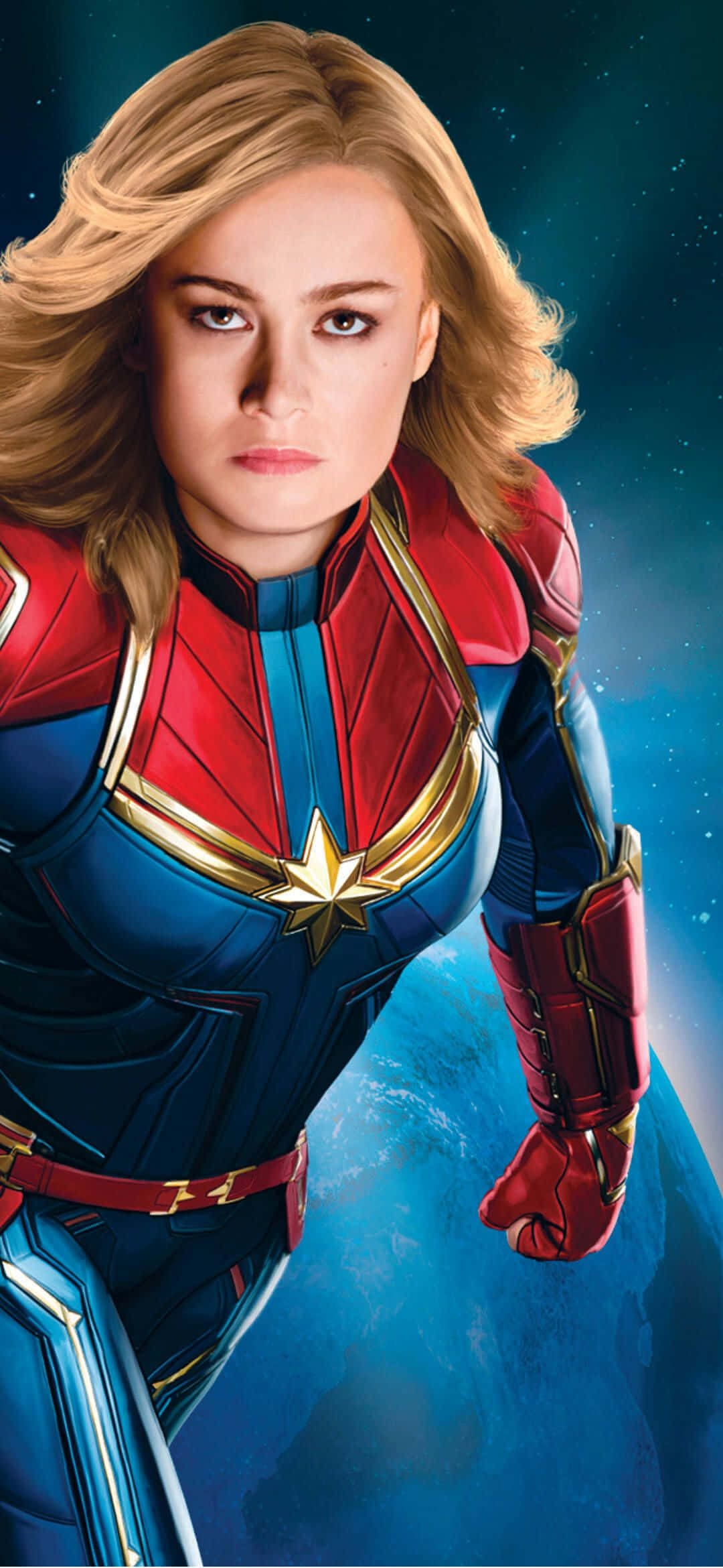 「Captain Marvel 釋放宇宙力量」圖片 壁紙 — 驚奇隊長穿著她標誌性的紅藍金戰服，自信地站在宇宙背景前，地球在她身後可見。