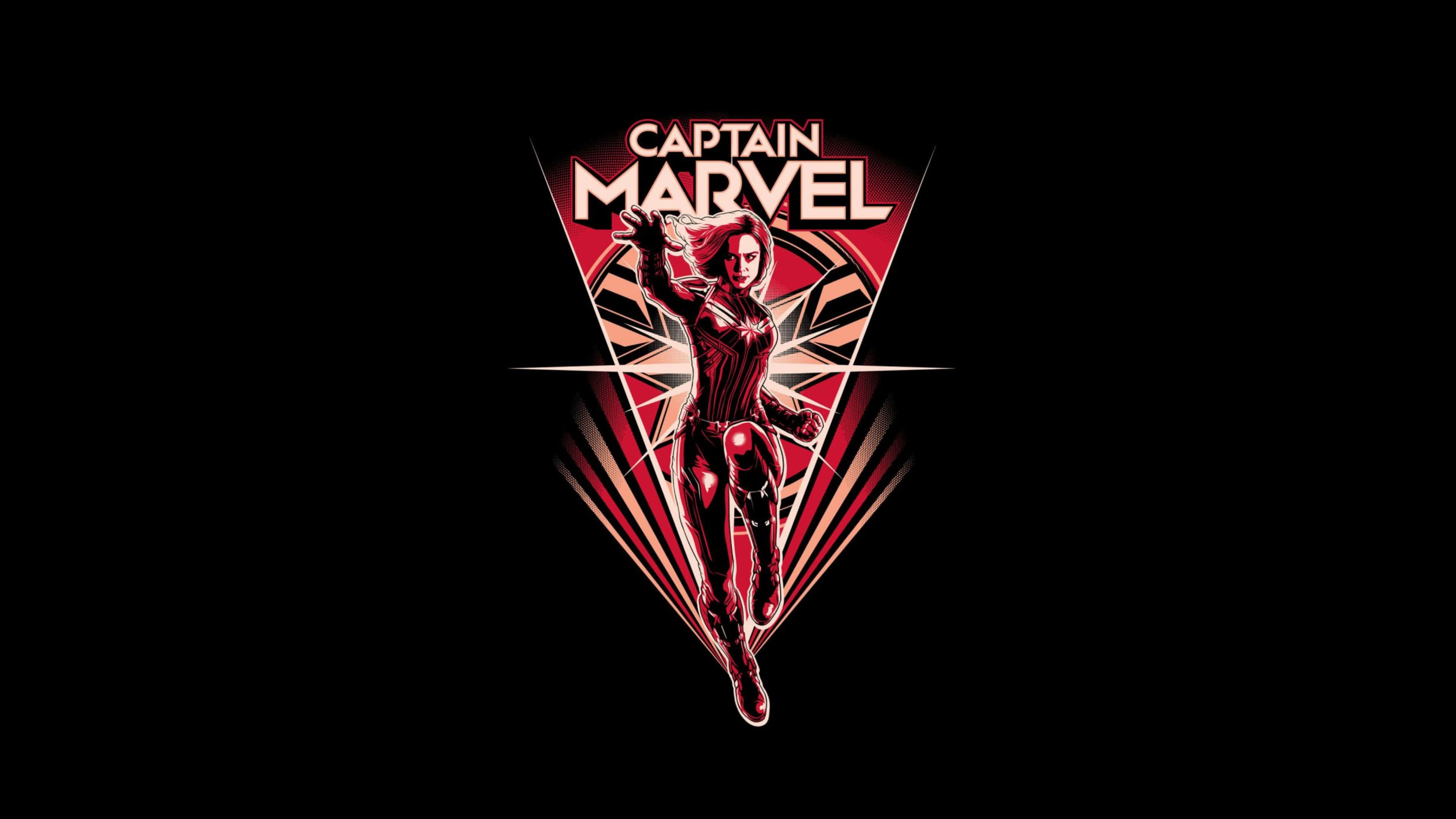 4K Marvel 壁紙 桌布 壁紙 — Captain Marvel 在深色背景上以紅色和黑色的幾何標誌動態地站立。