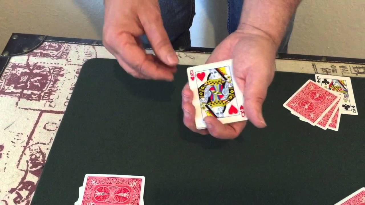 特寫雙手在紙牌遊戲中拿著紅心皇后牌。