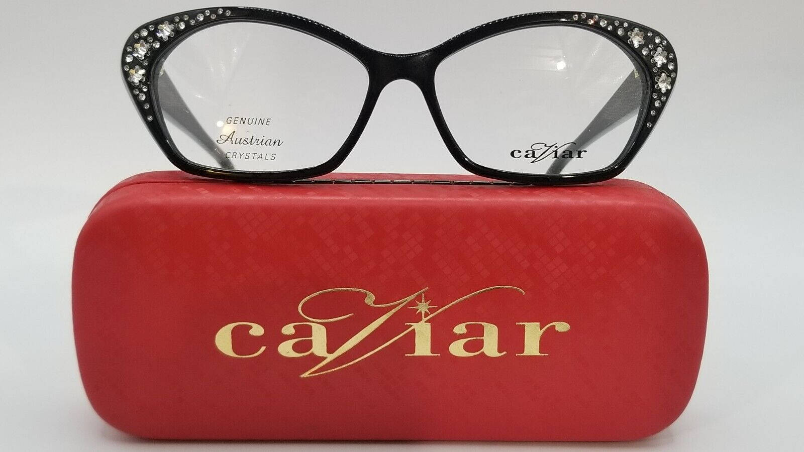 Caviar 3011款眼鏡 壁紙 — 優雅的黑框眼鏡綴以閃爍水晶，放在一個帶有金色魚子醬字樣的紋理紅色眼鏡盒上。