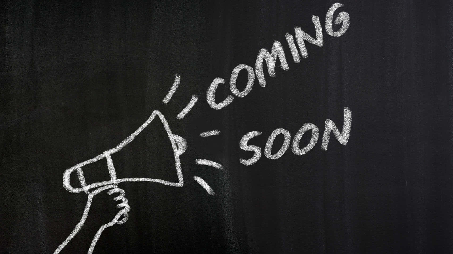 手拿擴音器，黑板上用粉筆寫著「coming soon」。
