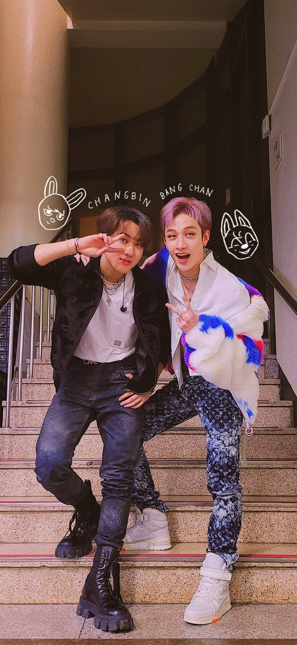 Changbin與Bang Chan 壁紙 — 兩名頭髮鮮艷的年輕男子在石階上擺出俏皮姿勢，上方有卡通兔子塗鴉和名字。