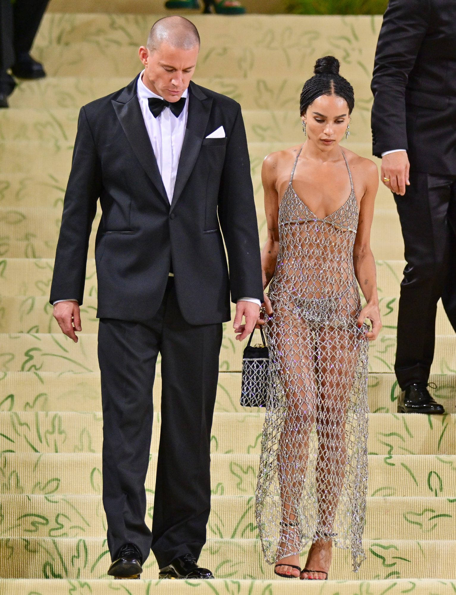 Channing Tatum 與女友 Zoë Kravitz 出席2021年Met Gala 壁紙 — 一名身穿黑色燕尾服的男士和一名身穿閃亮鎖子甲連衣裙的女士在華麗活動中走下裝飾華麗的樓梯。