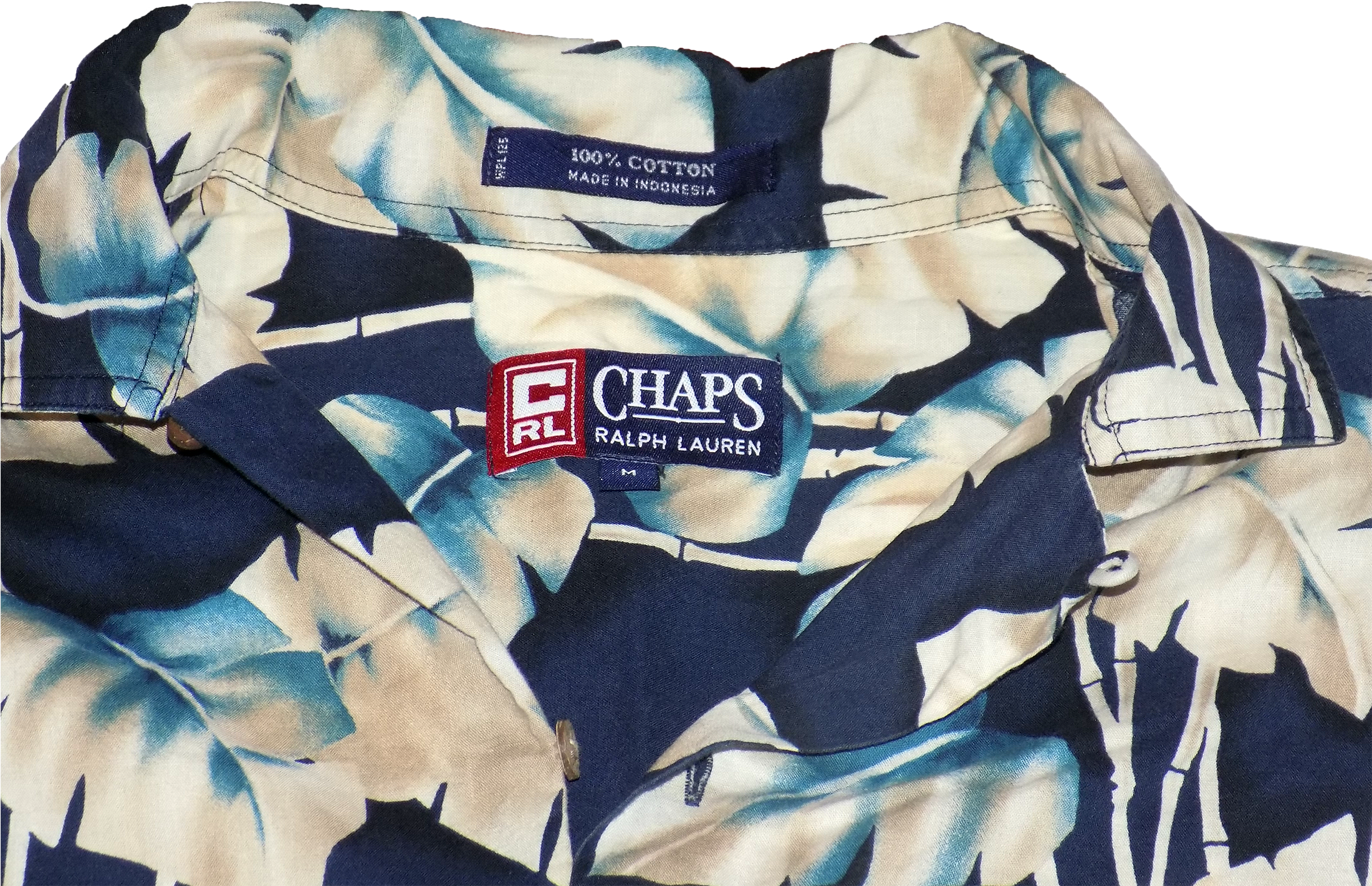 Chaps by Ralph Lauren 花紋襯衫 壁紙 — Chaps Ralph Lauren 藍色和奶油色熱帶葉子圖案襯衫領口的特寫，帶有可見的品牌標籤。
