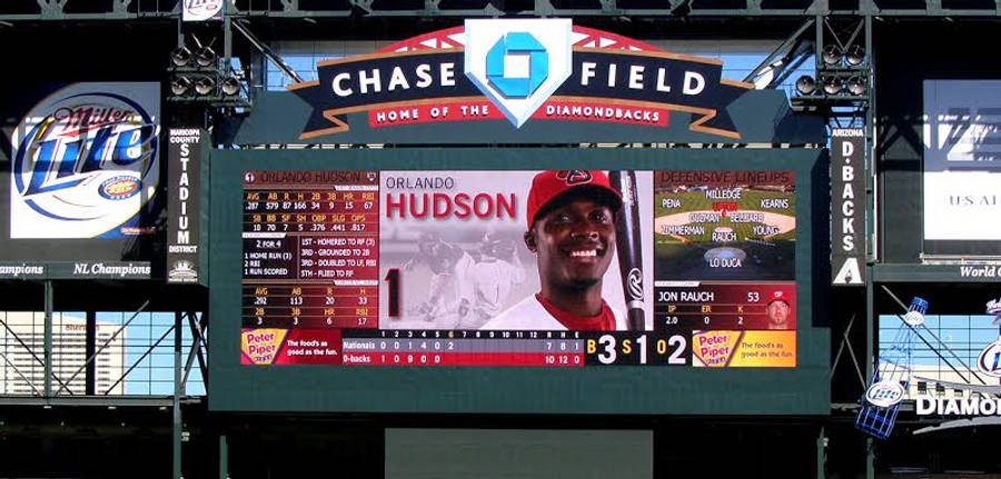 Chase Field球場MLB比分 壁紙 — 大屏幕上顯示奧蘭多·哈德森的統計數據和微笑照片，攝於大通球場的棒球比賽期間。