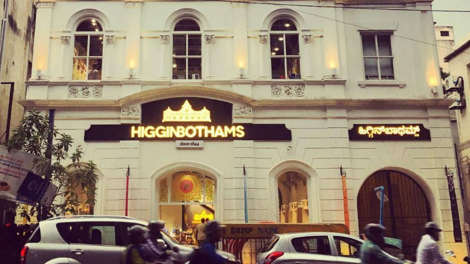 歷史悠久的白色建築，帶有 Higginbothams 標誌和繁忙的街景。