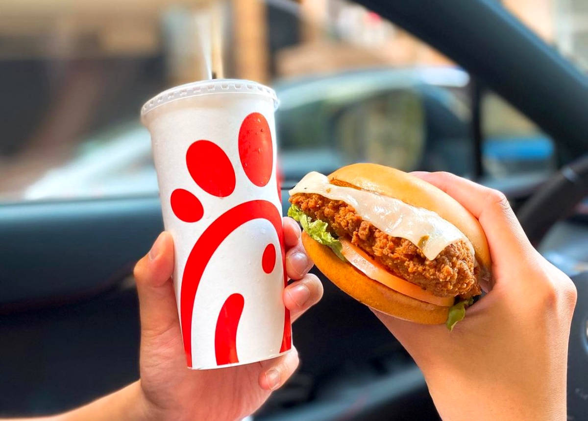 Chick Fil A 天使之餐 壁紙 — 兩隻手在日間於車內拿著一份Chick-fil-A雞肉三文治和一杯飲品。