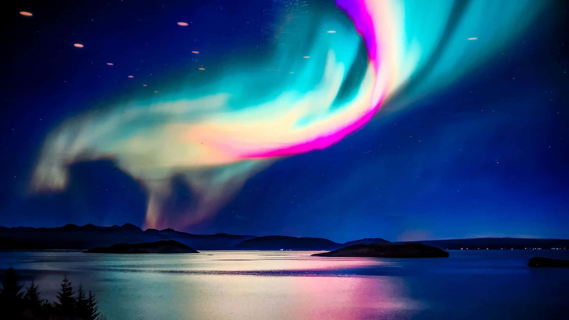 在星空下，色彩繽紛的北極光照耀在黑暗的湖面上。